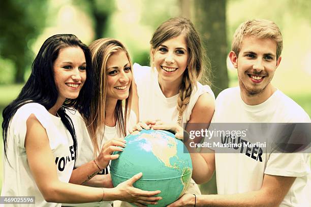 friends holding a globe - charity ball stock pictures, royalty-free photos & images