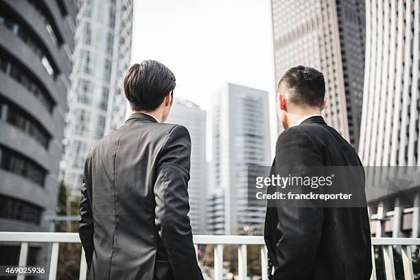 japanese businessman standing on the city - fine art portrait stockfoto's en -beelden