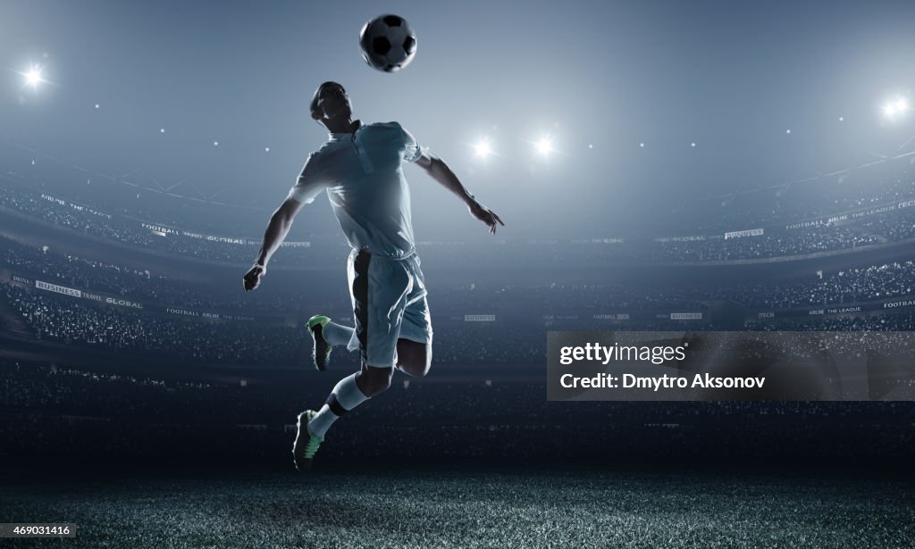 Soccer player kicking ball in stadium