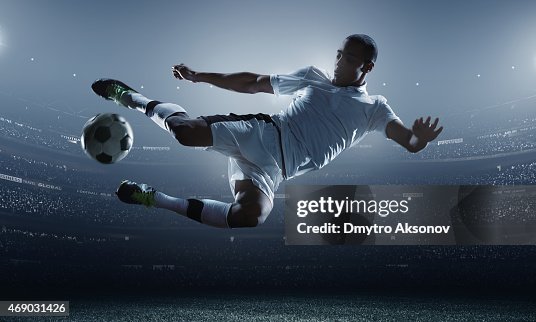 Soccer player kicking ball in stadium Soccer player kicking ball in stadium