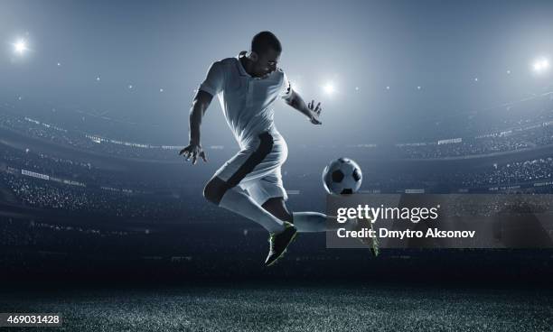 jugador de fútbol coleando en el estadio ball - términos deportivos fotografías e imágenes de stock