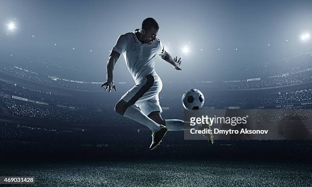 soccer player kicking ball in stadium - playing to win stockfoto's en -beelden