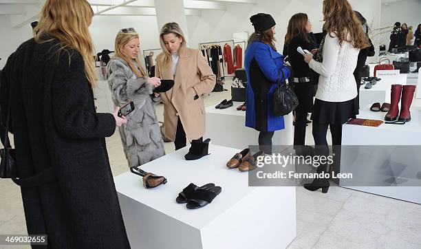 Various members of the press gather around some of the new items featured during the Newbark presentation during Mercedes-Benz Fashion Week Fall 2014...