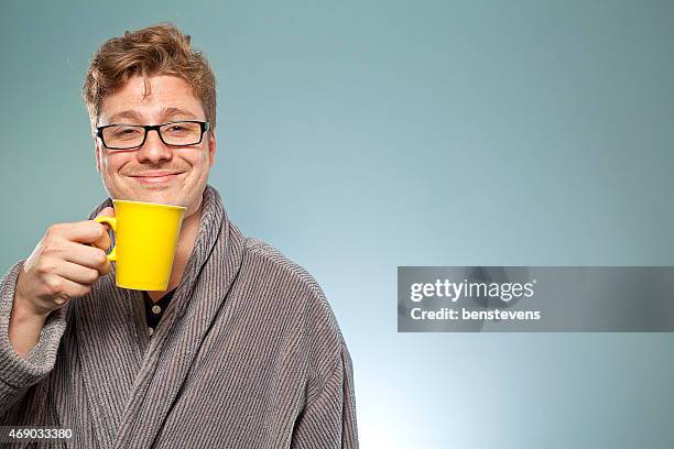 smiling intelligent looking mature man drinks coffee - bathrobe 個照片及圖片檔