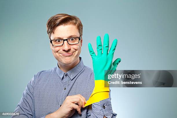 naiv guy putting gummi-handschuhe - situationskomik stock-fotos und bilder