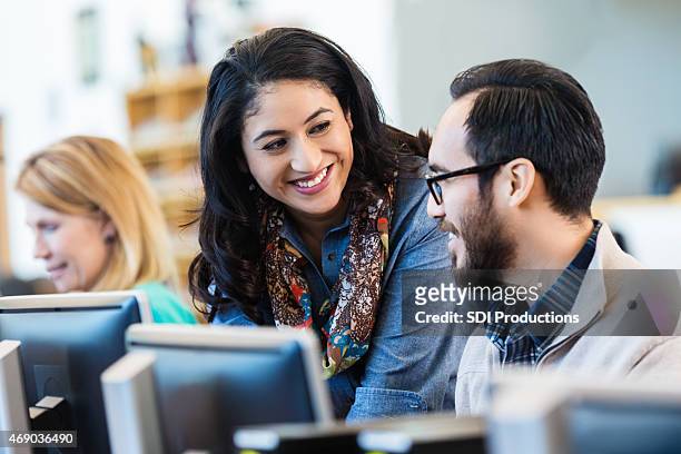 friendly hispanic woman talking with college classmate - adult student stock pictures, royalty-free photos & images