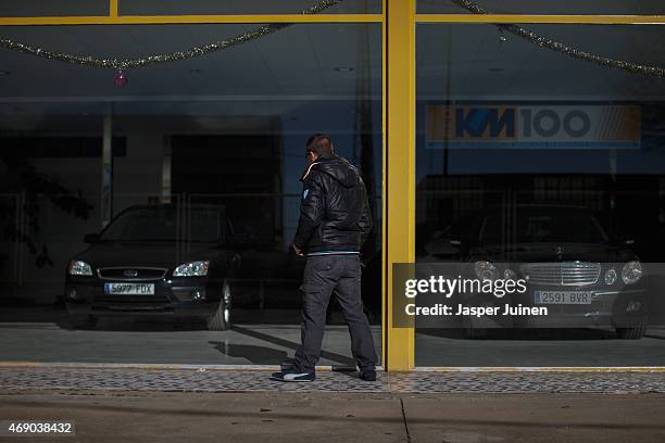 Angel junior looks at his car, that he is still paying in installments, standing for sale at a car dealer on December 21 in Villacanas,, Spain. Angel...