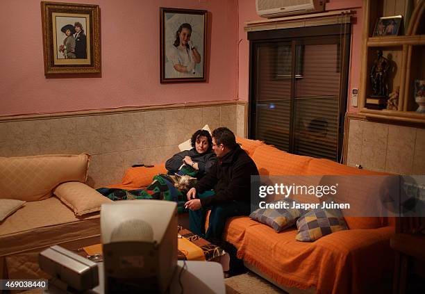 Former door factory workers Angel and his wife Regina sit on their sofa at home, dressed against the cold as they are unable to afford diesel oil to...