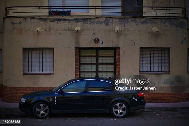 Car stands parked in front of a deteriorating apartment building, remembering to better times, on December 22 in Villacanas,, Spain. Everything is...