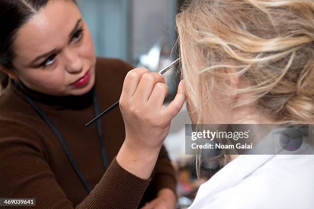 Model prepares backstage at the Michael Kors Show during Mercedes-Benz Fashion Week Fall 2014 at Spring Studios on February 12, 2014 in New York City.