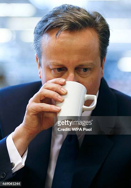 Prime Minister David Cameron takes a drink during a visit to Camira, a textile factory in Colne Valley, Yorkshire on April 9, 2015 in Colne, England....