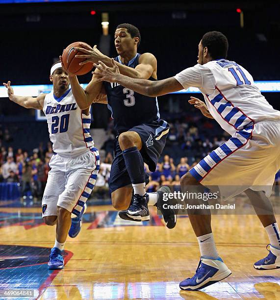 Josh Hart of the Villanova Wildcats drives between Brandon Young and Forrest Robinson of the DePaul Blue Demons at the Allstate Arena on February 12,...