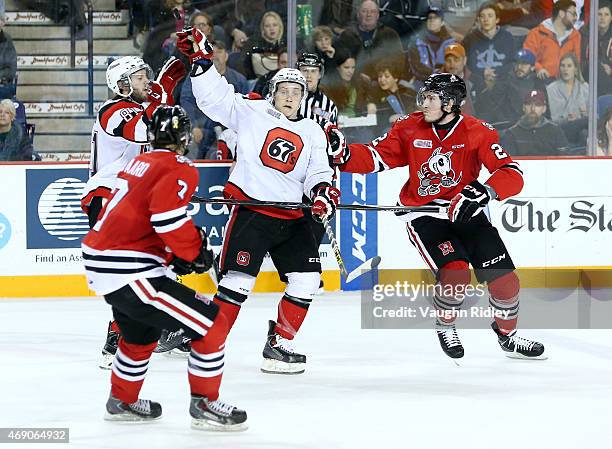 Nathan Todd and Dante Salituro of the Ottawa 67's grab for the puck during Game 6 of the Eastern Conference Quarter-Finals against the Niagara...