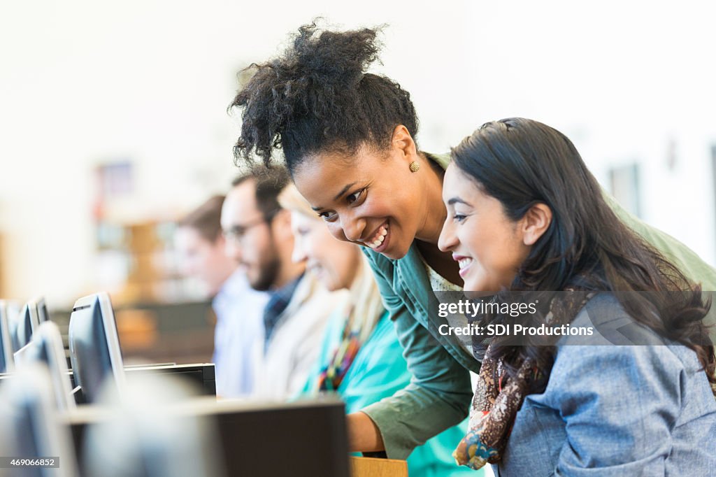 Diverse mid adult students using computers during class in college