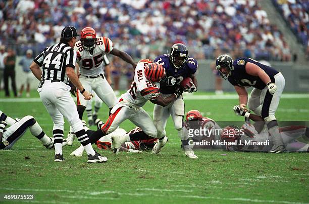 Runningback Priest Holmes of the Baltimore Ravens runs the ball down the middle for a few extra yards and is tackled by Safety Cory Hall of the...