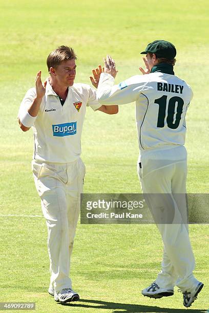 Xavier Doherty and George Bailey of the Tigers celebrate the wicket of Mitchell Marsh of the Warriors during day two of the Sheffield Shield match...