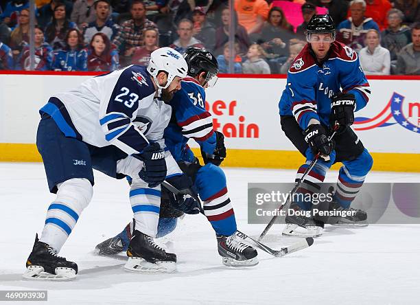 Jay Harrison of the Winnipeg Jets draws a penalty for tripping against Joey Hishon of the Colorado Avalanche at Pepsi Center on April 9, 2015 in...