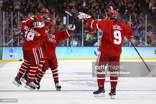 Robbie Baillargeon, Brandon Fortunato and Jack Eichel congratulate A.J. Greer of the Boston University Terriers after he scored against North Dakota...