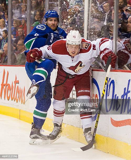 Yannick Weber of the Vancouver Canucks and Henrik Samuelsson of the Arizona Coyotes collide along the end boards in NHL action on April 2015 at...