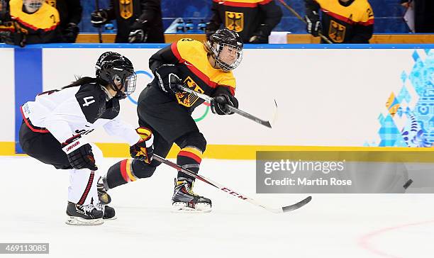 Sophie Kratzer of Germany fires the puck against Ayaka Toko of Japan in the second period during the women's Ice Hockey Preliminary Round Group B...