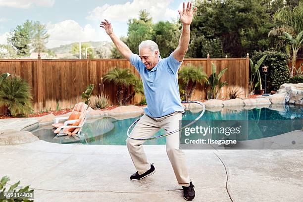 homem idoso dando hula hoop - jogar ao arco imagens e fotografias de stock