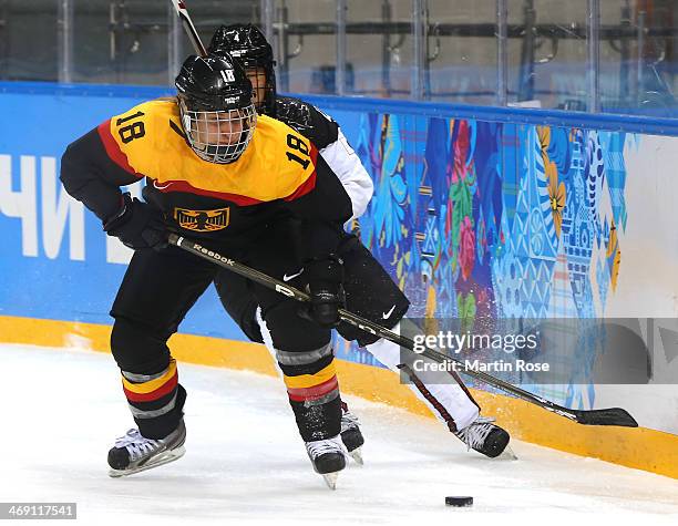 Susanne Fellner of Germany handles the puck against Ayaka Toko of Japan in the third period during the women's Ice Hockey Preliminary Round Group B...