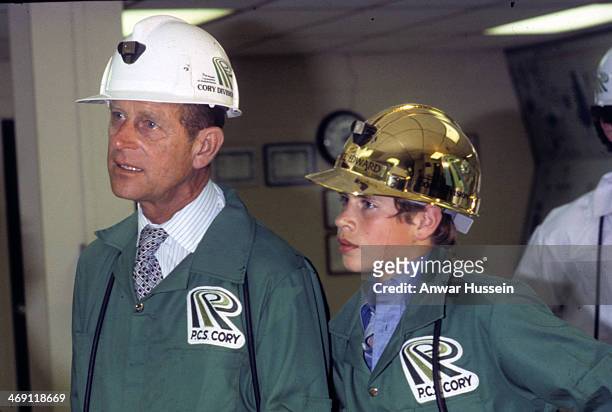 Prince Edward, accompanied by Prince Philip, Duke of Edinburgh, is provided with a protective gold helmet as he visits a P.C.S. Cory mine on July 01,...