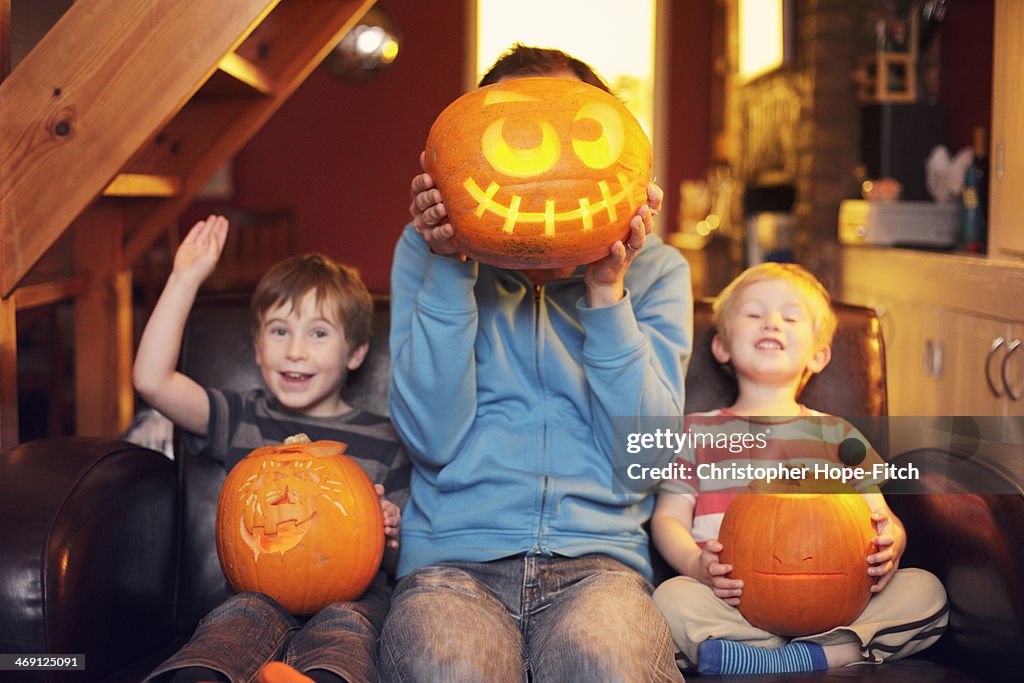 Father and sons with carved pumpkins