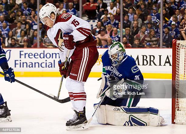 Goalie Eddie Lack of the Vancouver Canucks makes a save while screened by Henrik Samuelsson of the Arizona Coyotes in NHL action on April 9, 2015 at...