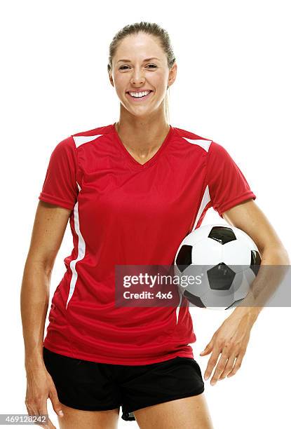 cheerful female soccer player holding ball - womens football stock pictures, royalty-free photos & images