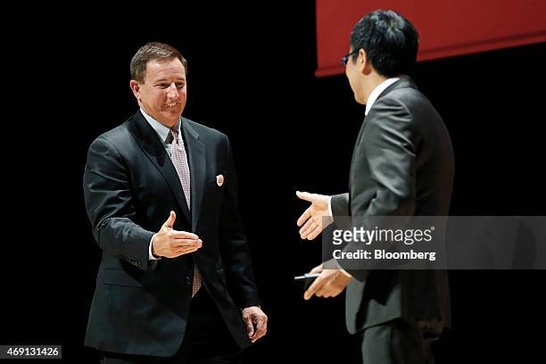 Mark Hurd, co-chief executive officer of Oracle Corp., left, walks towards Ken Miyauchi, executive vice president of SoftBank Corp., to shake hands...