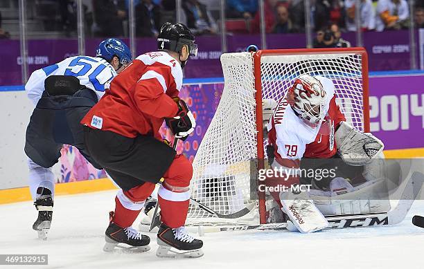 Austria goalie Bernhard Starkbaum blocks a shot by Finland forward Juhamatti Aaltonen during the second period in a men's hockey game at the Winter...