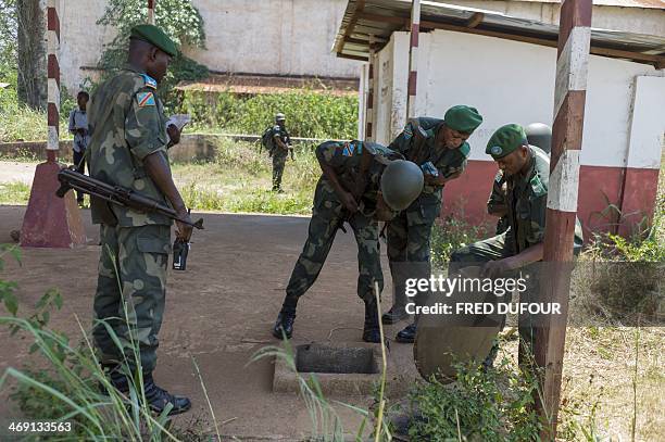 Militaries cover the trap door of a petrol tank where several dead bodies lay in a former military camp used by ex seleka rebels, in Bangui, on...