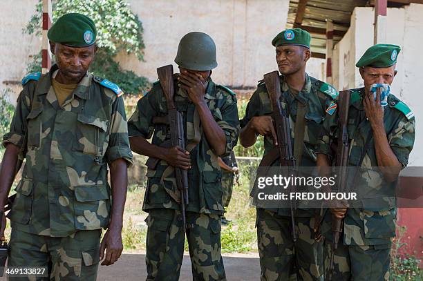 Militaries cover their nose after discovering a petrol tank containing several dead bodies in a former military camp used by ex seleka rebels, in...
