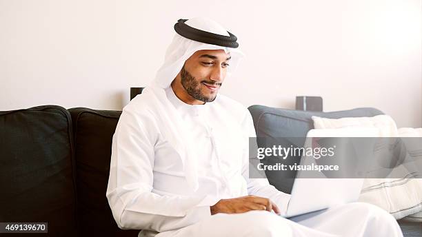 arab man using laptop - emirati laptop stock pictures, royalty-free photos & images