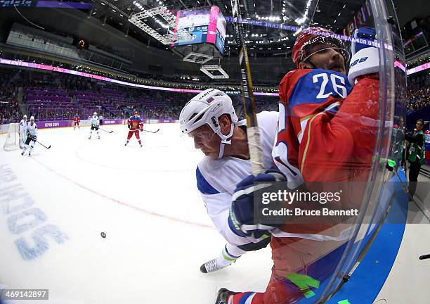 Andrej Tavzelj of Slovenia checks Vyacheslav Voynov of Russia into the glass in the first period during the Men's Ice Hockey Preliminary Round Group...