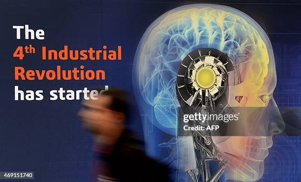 Worker passes a display lettering "The 4th Industrial Revolution has started" prior to the opening of the Hannover Messe industrial trade fair on...