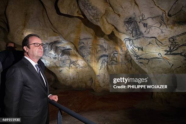 French President Francois Hollande looks at replicas of cave paintings as Pascal Terrasse, President of the Cavern of Pont-d'Arc Grand Project,...