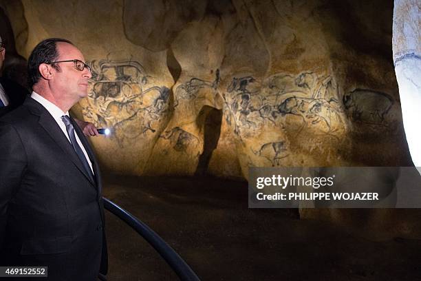 French President Francois Hollande looks at cave paintings in a replica of the Chauvet Cave during his inauguration visit to Vallon Pont d'Arc, on...