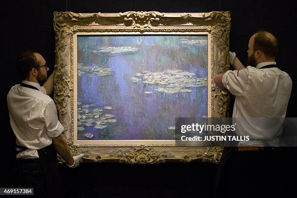 Employees of Sotheby's auction house hang French artist's Claude Monet's Nympheas painted in 1905 which is estimated to sell for 30-45 million USD at...