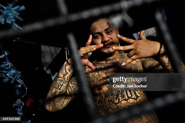 Member of the 18th Street gang shows a hand sign that represents his gang in a cell at a detention center on February 20, 2014 in San Salvador, El...