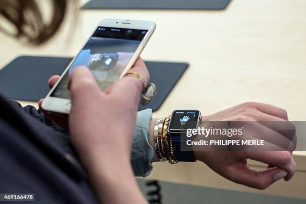 Customer uses an iPhone 6 smartphone to take a photo of a model of the Apple Watch during the device presentation at the Apple Store in Lyon,...