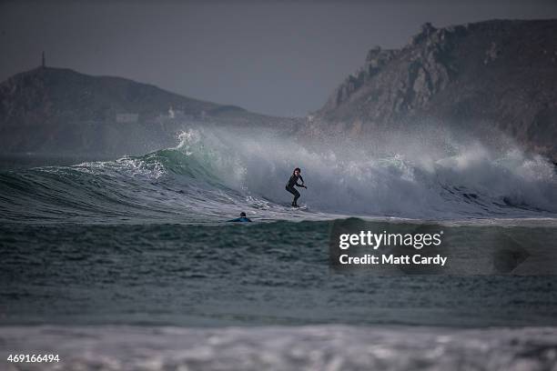 Surfer catches a wave as the sun sets over Sennen Cove on April 9, 2015 in Cornwall, England. Prime Minister David Cameron has said that the six...