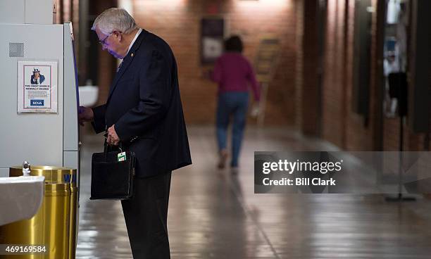 Senate Budget chairman Mike Enzi, R-Wyo., uses the Senate Federal Credit Union ATM in the basement of the Russell Senate Office Building on Friday,...