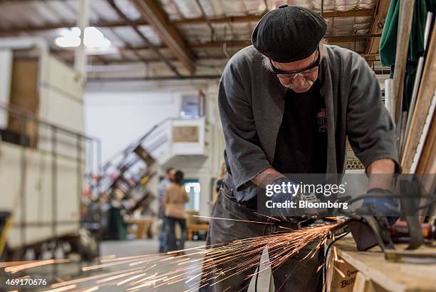 Artist Tim Kelly grinds a piece of iron n this photo taken with a tilt-shift lens at the art co-op The Generator in Reno, Nevada, U.S., on Friday,...