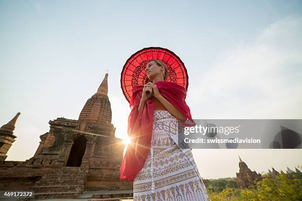 jovem mulher no bagan templos no myanmar ao pôr do sol - pagode imagens e fotografias de stock