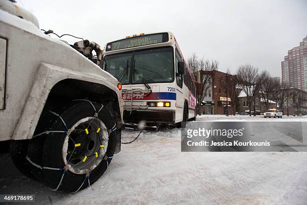 Police work to tow away a Septa bus that slid off the road on February 13, 2014 in Philadelphia, Pennsylvania. The east coast was hit with a winter...