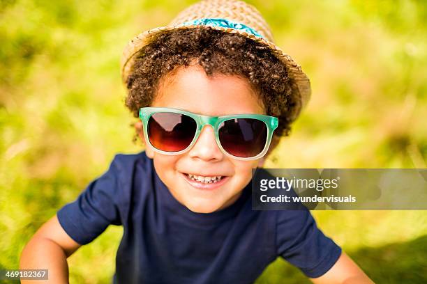 little boy smiling at camera in park - sun hat stock pictures, royalty-free photos & images