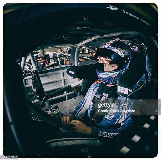 Trevor Bayne, driver of the AdvoCare Ford, sits in his car in the garage area during practice for the NASCAR Sprint Cup Series Duck Commander 500 at...