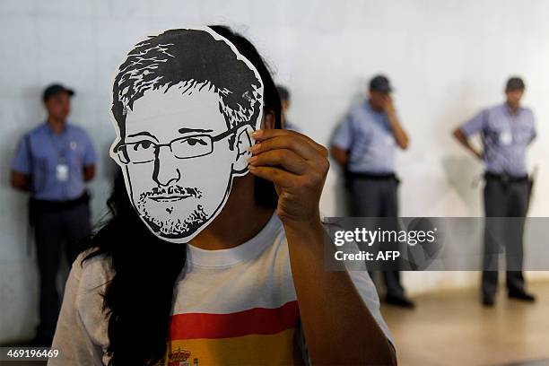 Member of the Avaaz online community organization wears a "Snowden" mask during the delivery at the the Itamaraty Foreign Ministry Palace of...